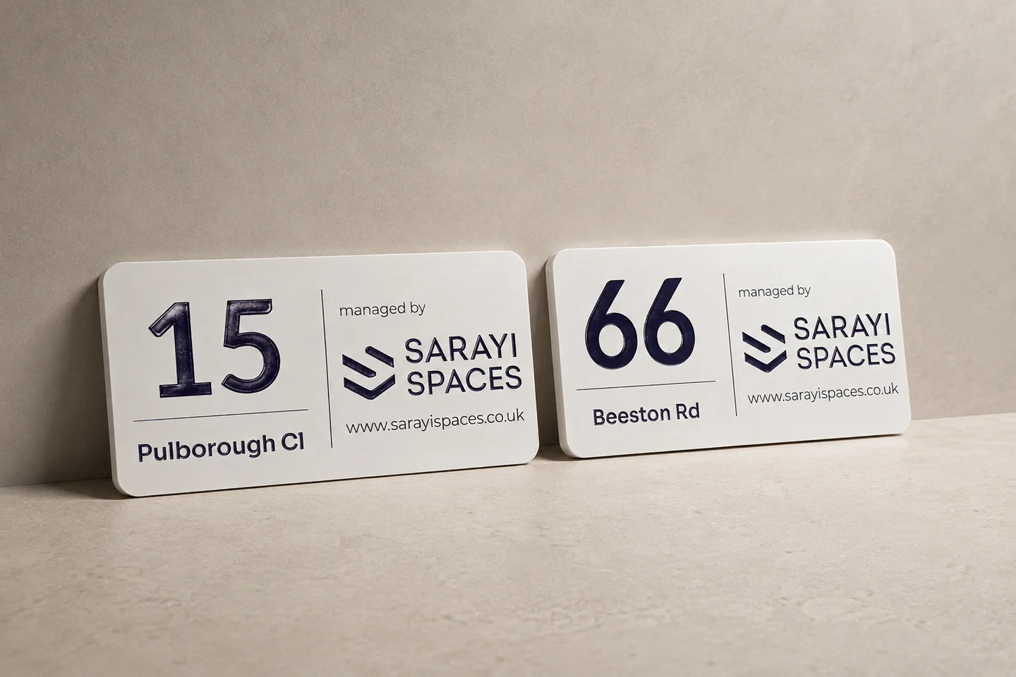 Sarayi Spaces property identification plaques for 15 Pulborough Cl and 66 Beeston Rd, with raised numbers and managed-by branding